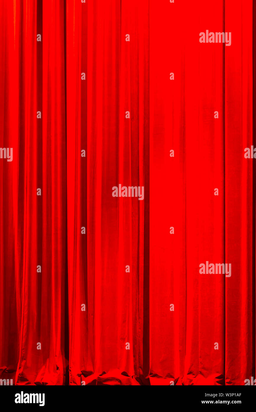 Vista frontale di una chiusura in stile vintage di velluto rosso teatro tenda illuminata da un faretto Foto Stock