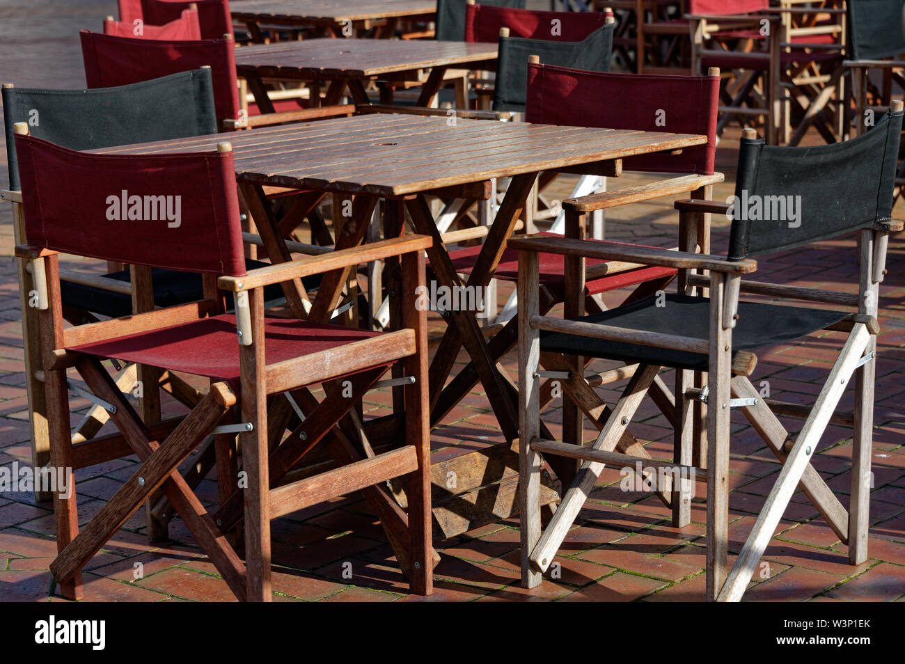 Un cafè al di fuori con tela, tavoli in legno e sedie. Foto Stock