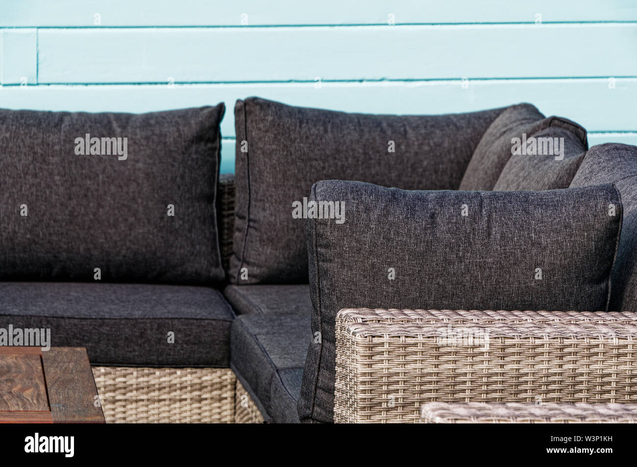 Un lettino per la veranda o patio, è costituita da un intreccio di vimini con grandi e comodi cuscini. Foto Stock