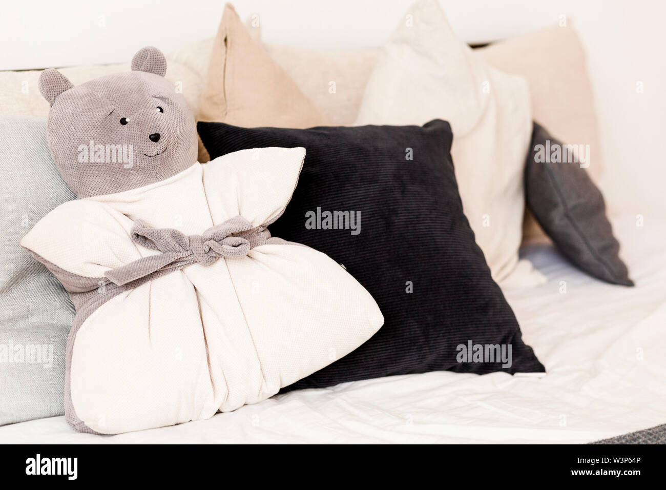 Foto del cuscino nella forma di un orso sdraiato sul letto Foto Stock