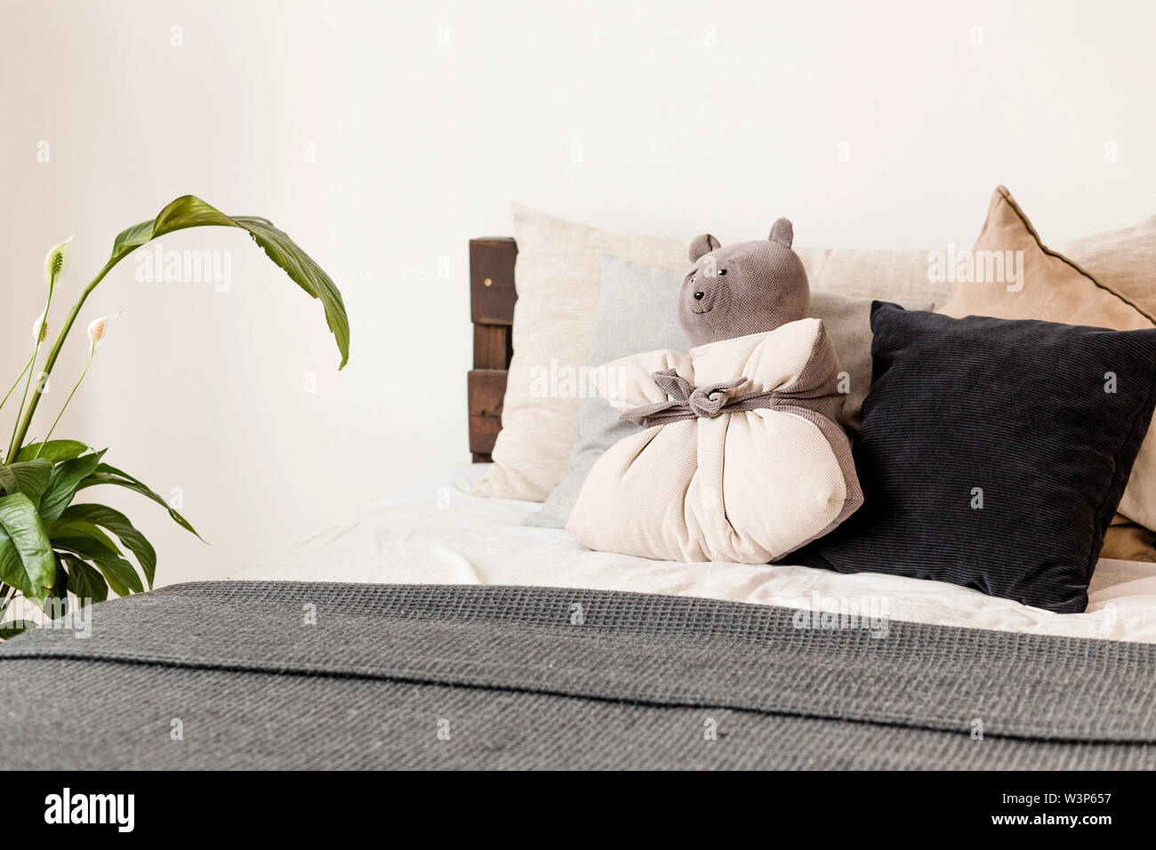 Foto del cuscino nella forma di un orso sdraiato sul letto Foto Stock