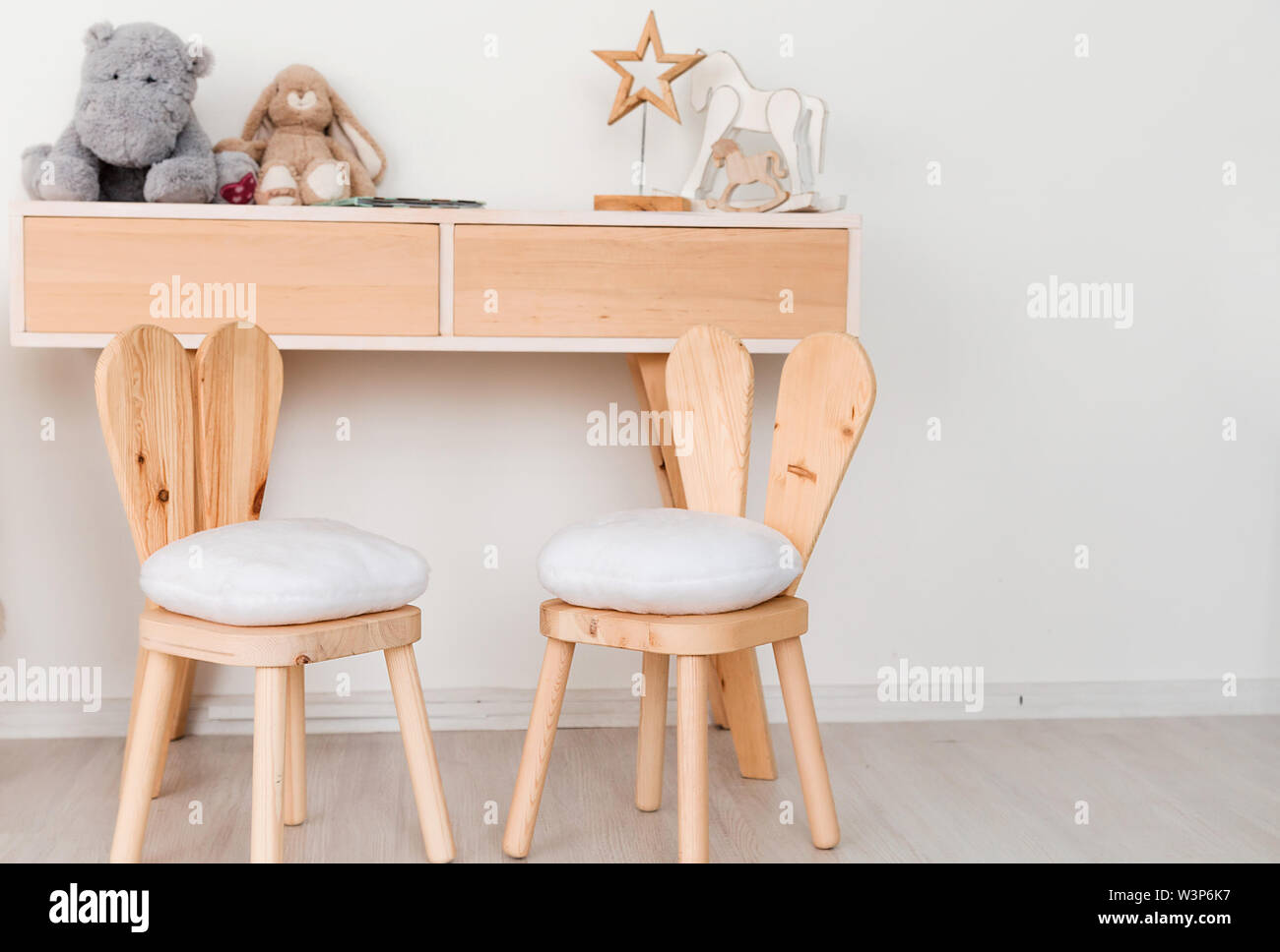 2 sedie con orecchie di coniglietto nella stanza dei bambini e una tavola con i giocattoli Foto Stock
