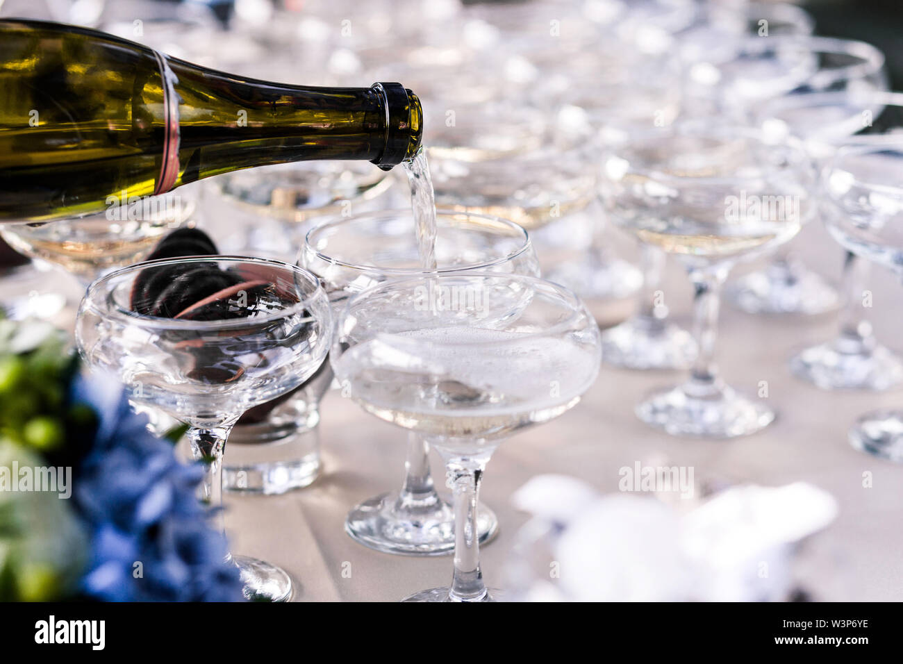 Champagne da bottiglia si riversa in una bella pulizia del vetro Foto Stock