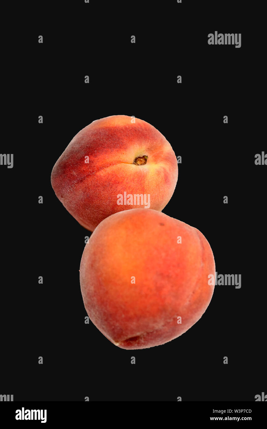 Fresche e mature pesche organico disposti su sfondo nero Foto Stock