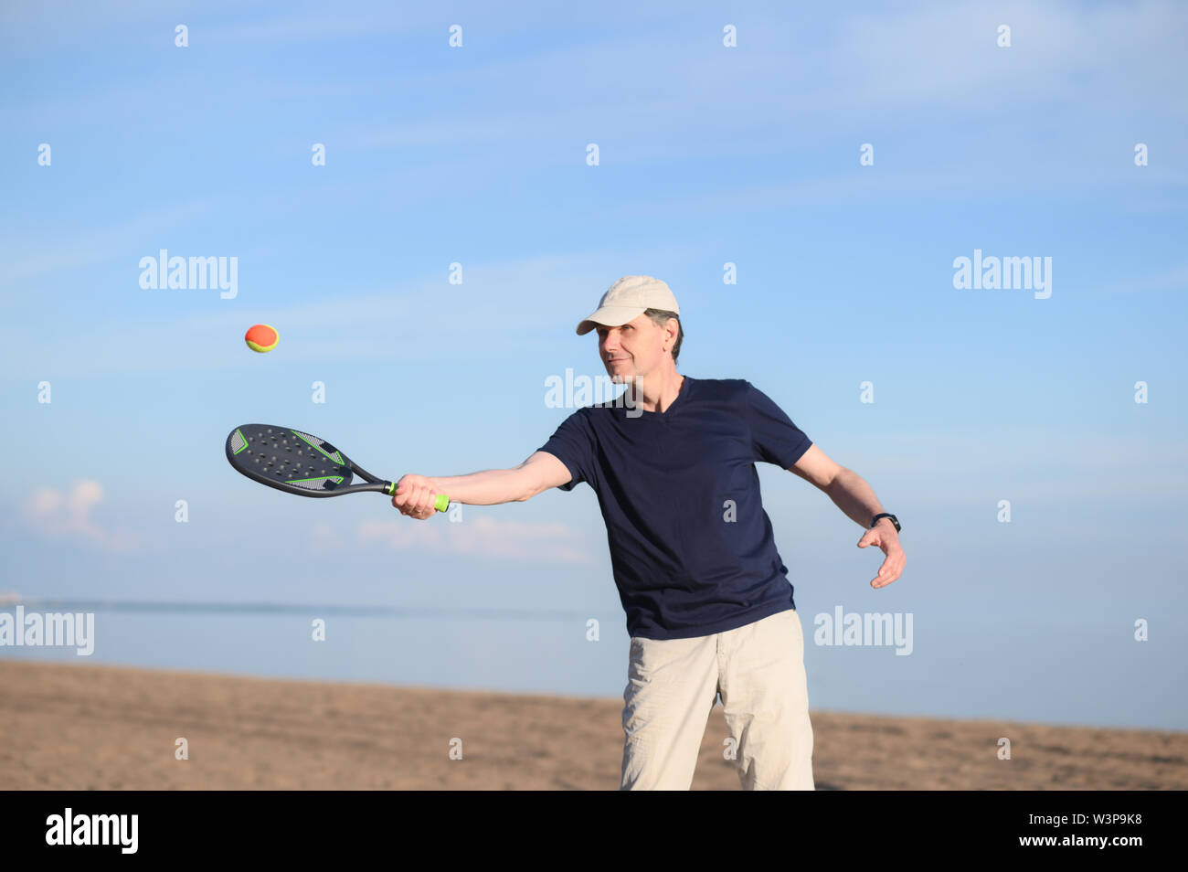 L'uomo gioca beach tennis su di una spiaggia di sabbia Foto Stock