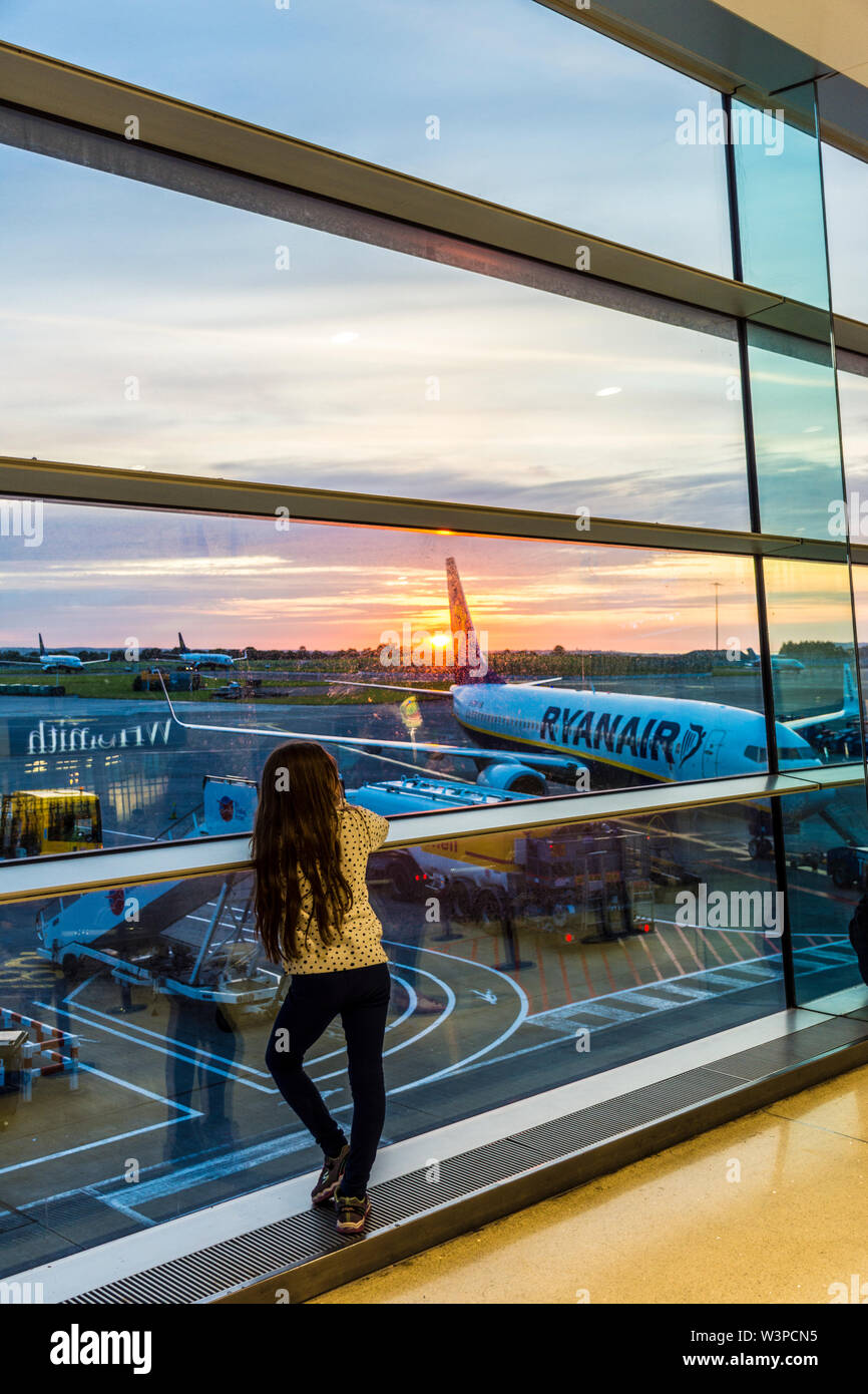 Aeroporto di Dublino, Terminal Uno, bambino, ragazza orologi sunrise. L'Irlanda Foto Stock