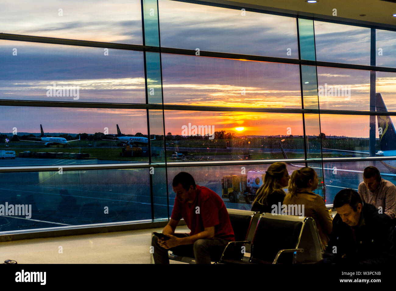 Aeroporto di Dublino, Terminal Uno, Sunrise oltre l'aviosuperficie e aeromobili parcheggiati. L'Irlanda Foto Stock