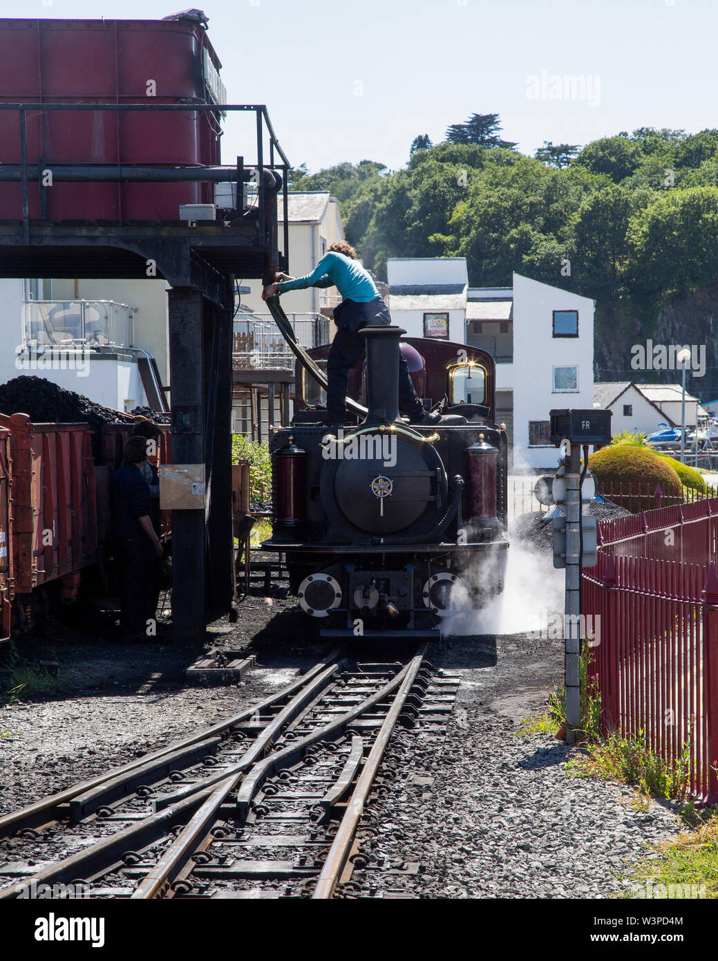 Un doppio Fairlie locomotore prende sul carbone e acqua a Porthmadog stazione sul Festiniog Railway Foto Stock
