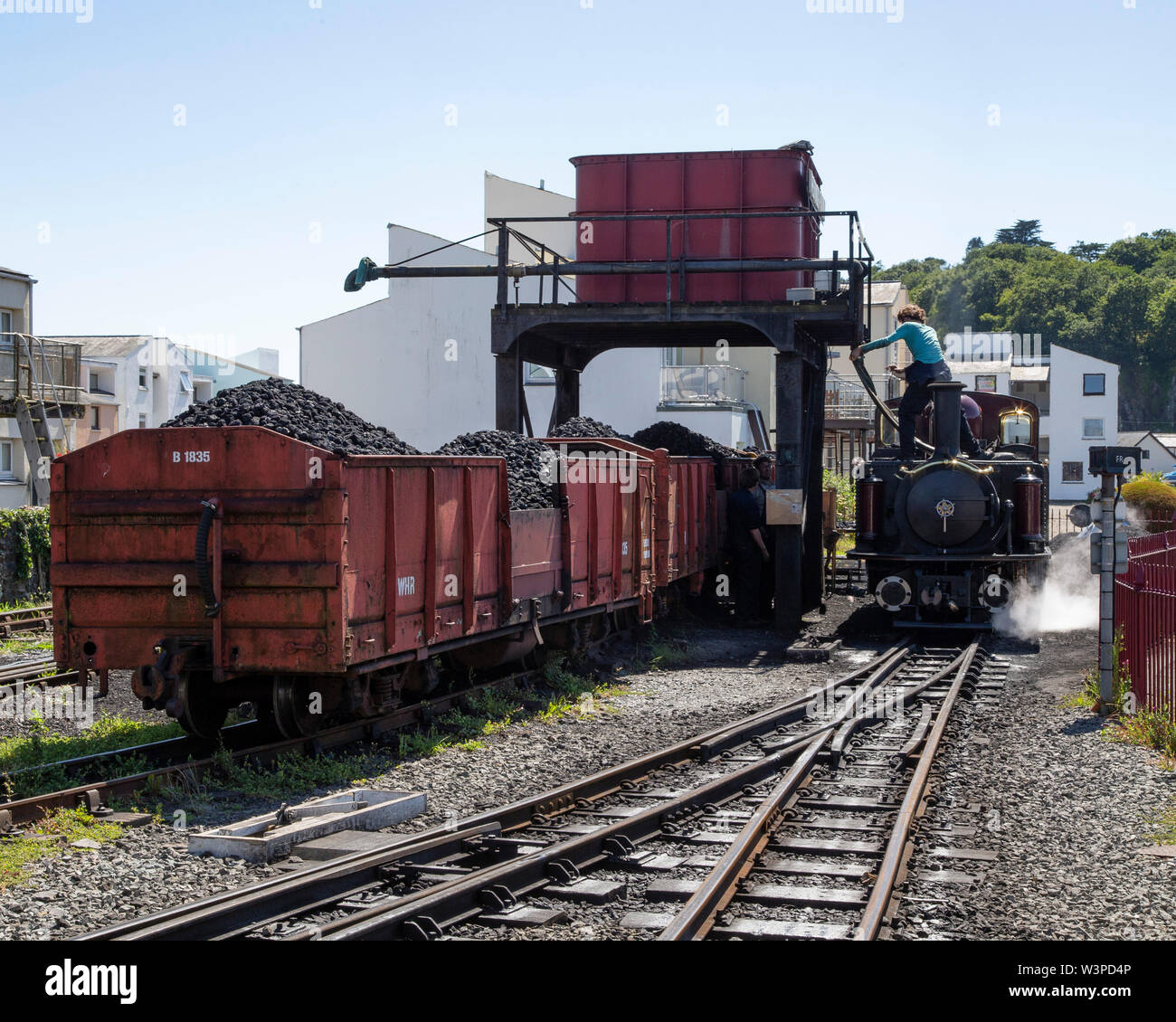 Un doppio Fairlie locomotore prende sul carbone e acqua a Porthmadog stazione sul Festiniog Railway Foto Stock