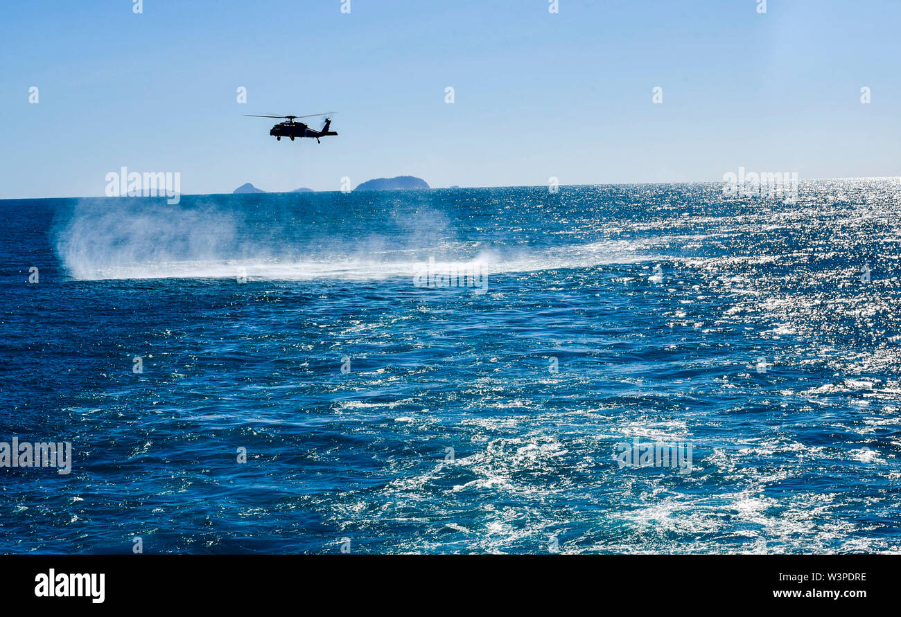 190716-N-DQ787-2037 CORAL SEA (Luglio 16, 2019)- Un MH-60S Seahawk elicottero, assegnato per l' isola dei Cavalieri di elicottero di mare squadrone di combattimento (HSC) 25, proviene da un hover dietro l'assalto anfibio nave USS Wasp (LHD 1). Wasp, ammiraglia di Wasp Expeditionary Strike gruppo, con avviato 31 Marine Expeditionary Unit, partecipa attualmente a Talisman Sabre 2019 al largo delle coste del nord Australia. Un accordo bilaterale, evento biennale, Talisman Sabre è progettato per migliorare NEGLI STATI UNITI Australia e combattere la formazione, la disponibilità e l' interoperabilità attraverso l' realistico, formazione pertinenti necessarie per AMI Foto Stock