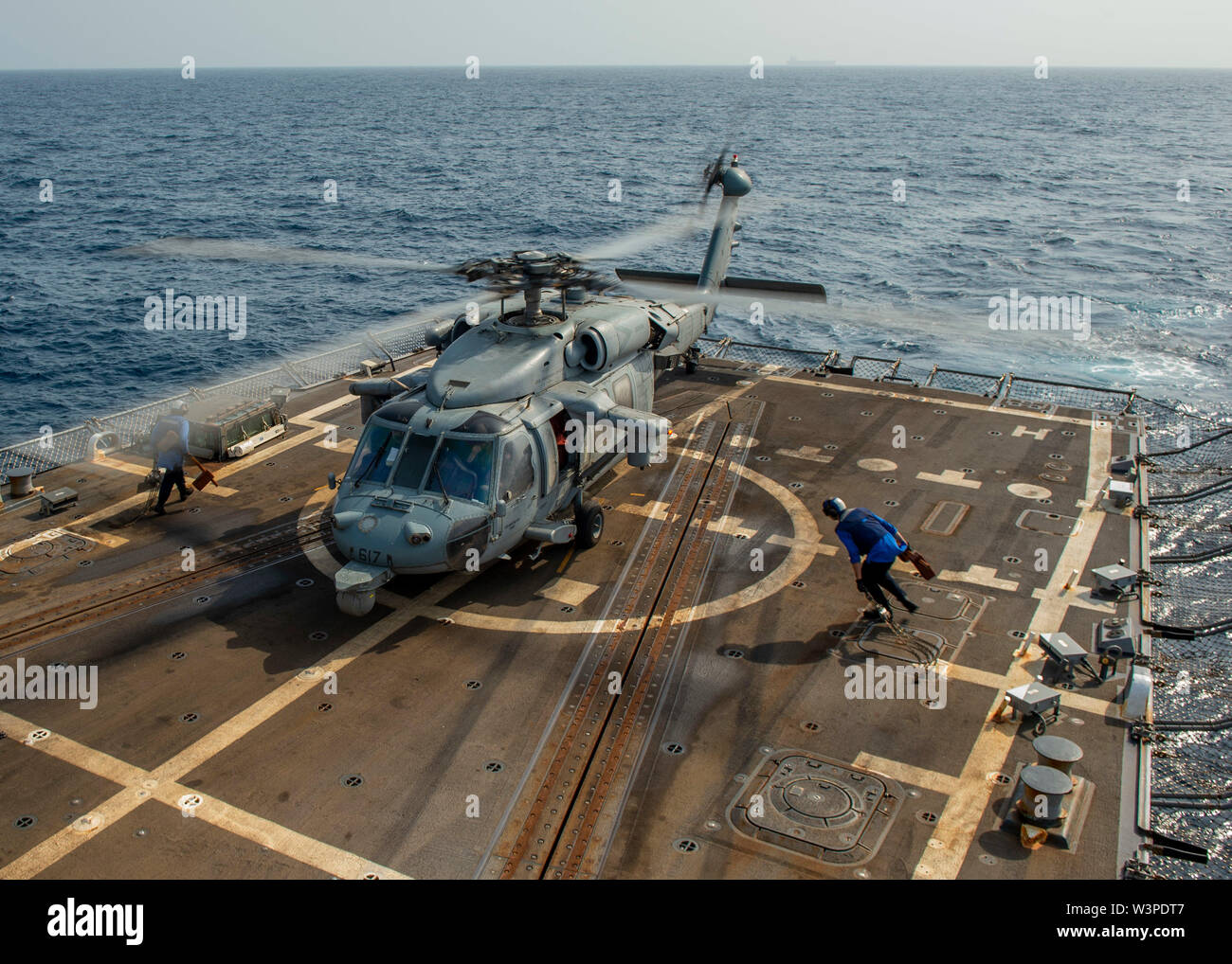 190714-N-SS350-1067 Golfo di Oman (Luglio 14, 2019) di Boatswain Mate 2a classe Andrea Bigenho, sinistra, da Pittsburg, Pa., marinaio e Michael Marcalus, da Berkeley Springs, W.Va., fissare un MH-60S Sea Hawk elicottero, assegnato al "Nightdippers" di elicottero di mare squadrone di combattimento (HSC) 5, per il ponte di volo a bordo del Arleigh Burke-class guidato-missile destroyer USS Bainbridge (DDG 96). Bainbridge è distribuito negli Stati Uniti Quinta Flotta area di operazione a sostegno di operazioni navali per garantire stabilità marittimo e la sicurezza nella regione centrale, collegando i paesi del Mediterraneo e del Pacifico attraverso th Foto Stock