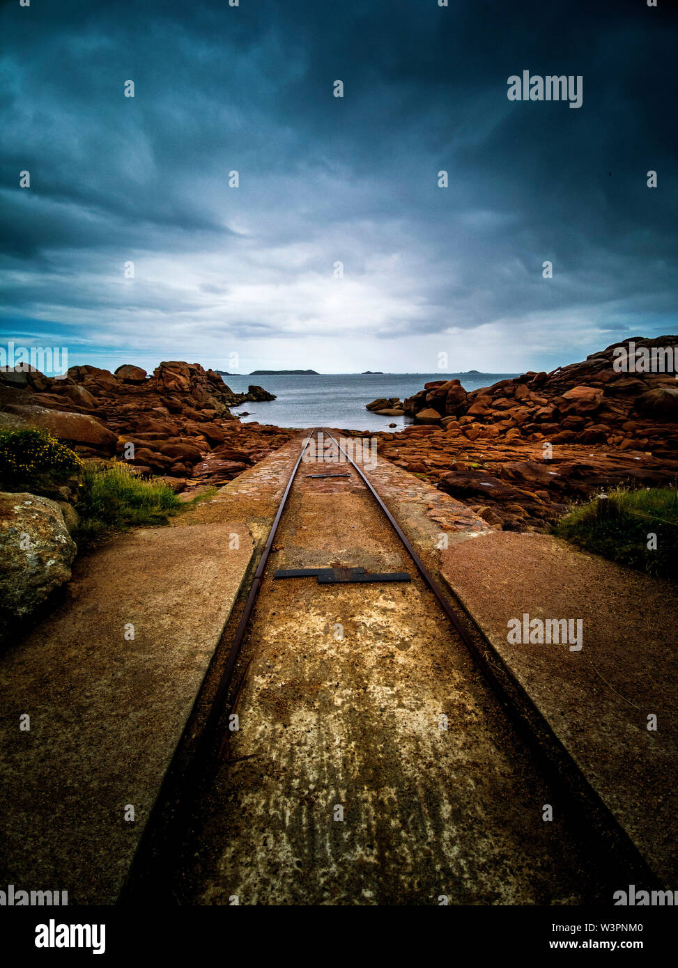 Le vie conducono giù al mare presso la stazione di salvataggio al francese Breton porto di pesca di Ploumanach. Bretagne. Francia Foto Stock