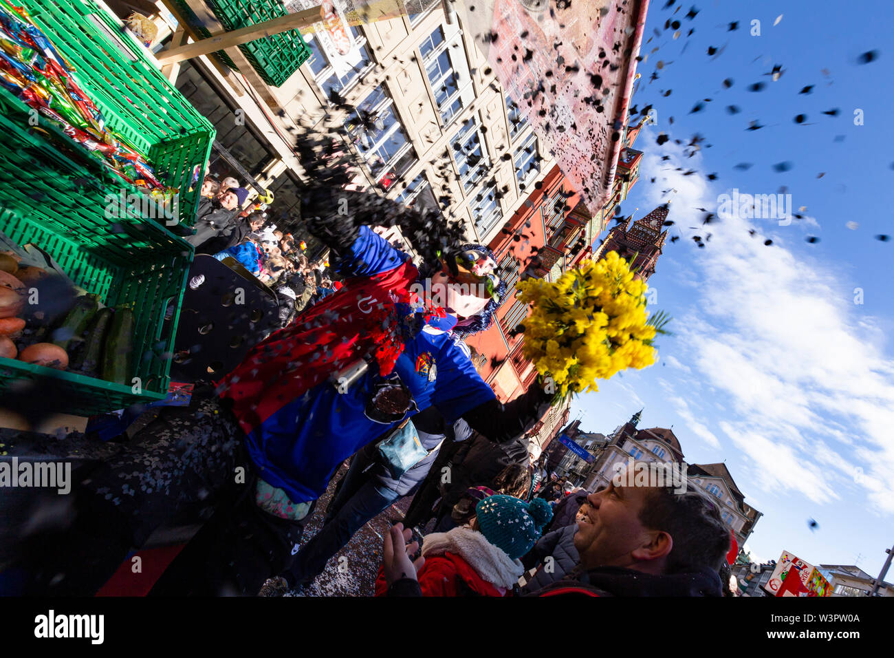 Marktplatz, Basilea, Svizzera - Marzo 13th, 2019. Close-up di un waggis gettando i residui di carta dal suo carnevale galleggiante Foto Stock