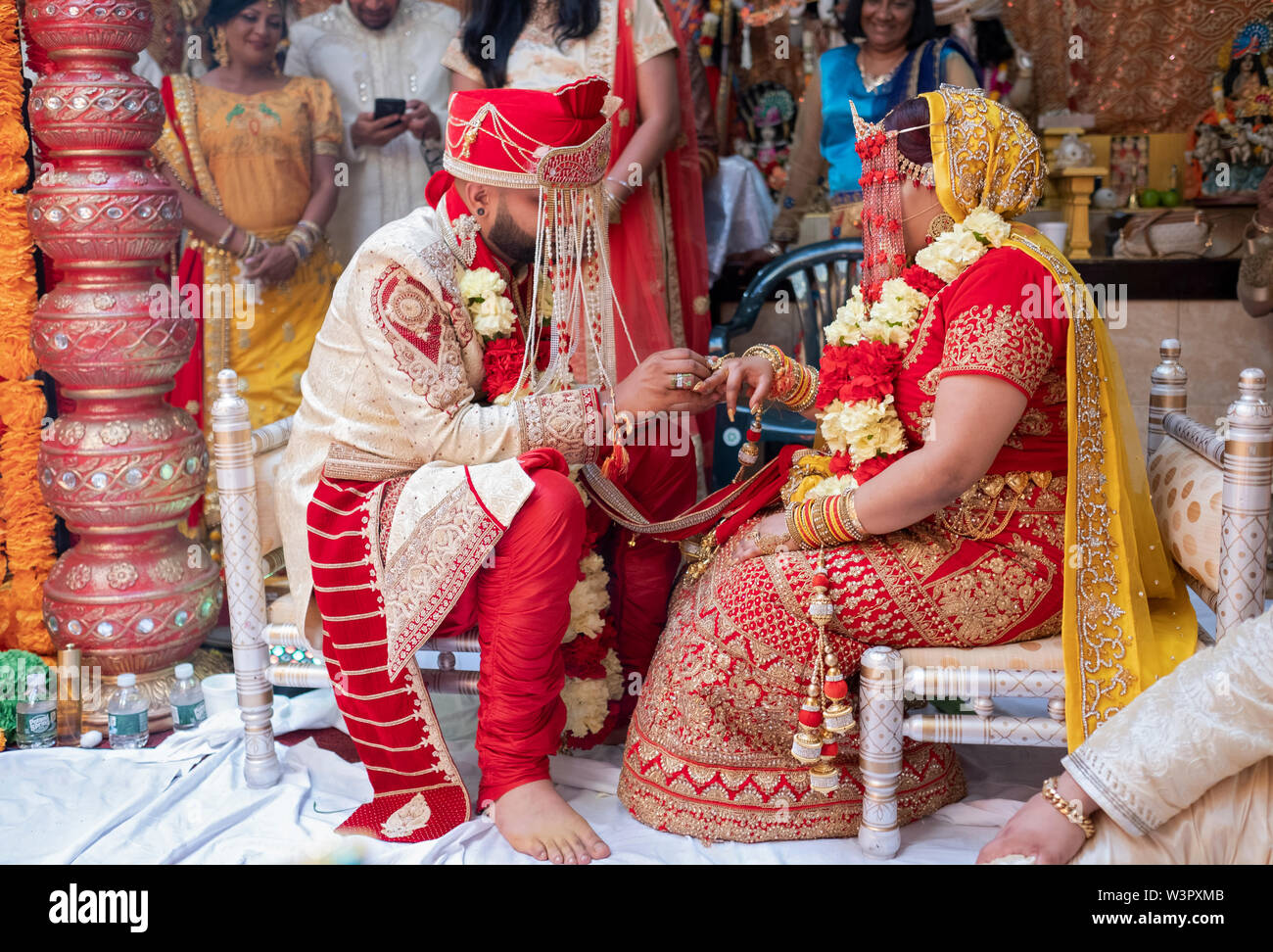 La sposa e lo sposo anelli di exchange durante un Indù tradizionale cerimonia di matrimonio in un tempio in Ozone Park, Queens, a New York City. Foto Stock
