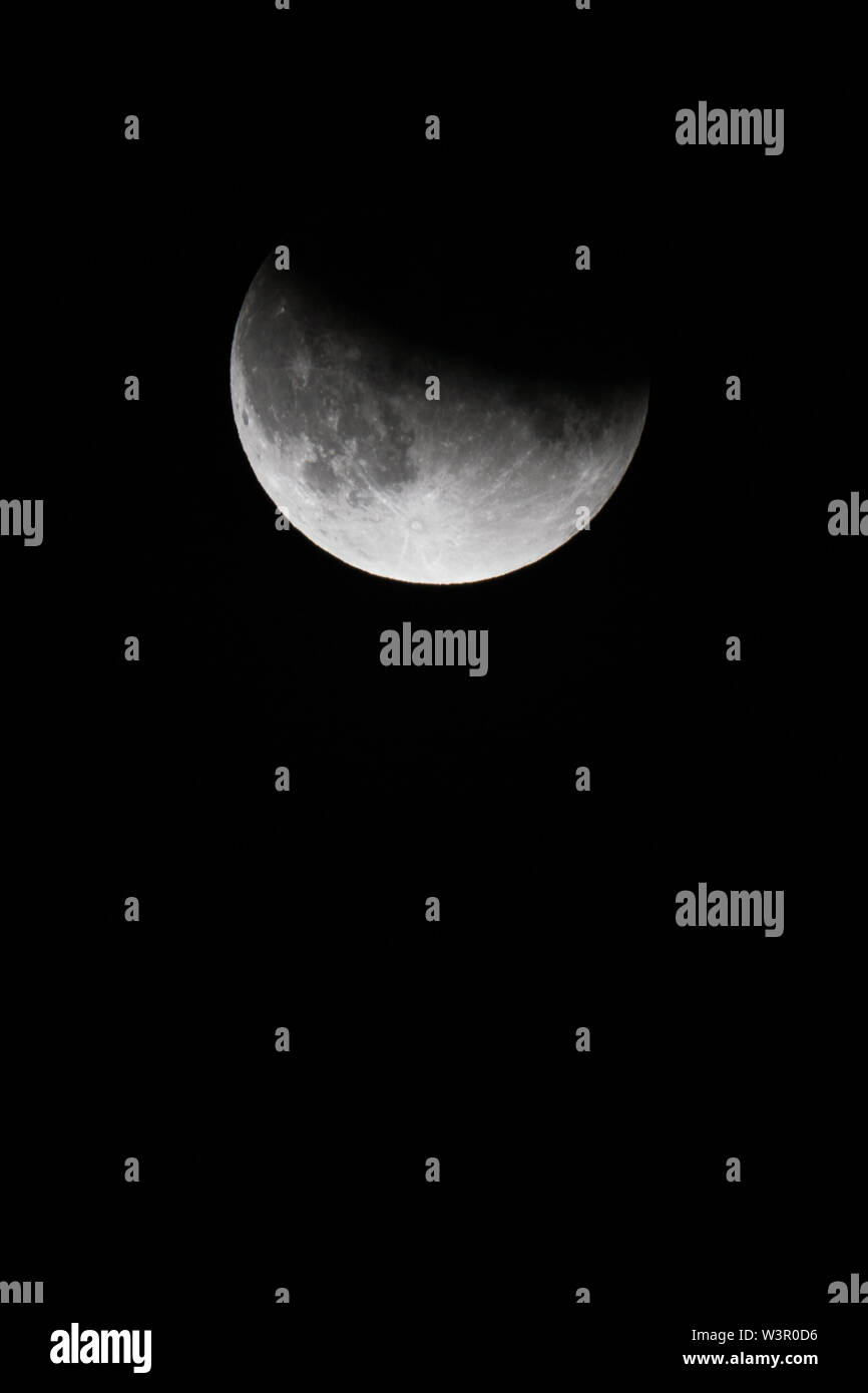 Vista ravvicinata di una Eclissi lunare parziale nel nero cielo notturno nel luglio 2019 Foto Stock