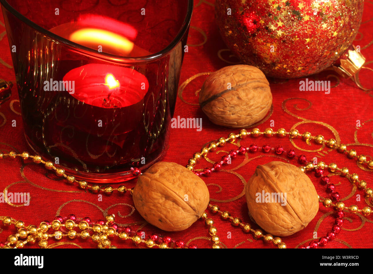 Natale Decorazioni per la tavola con le catene, candela e noci Foto Stock
