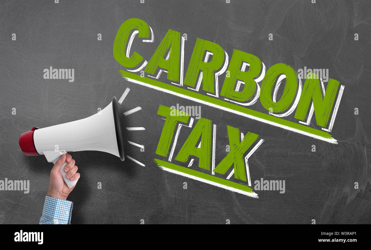Mano azienda megafono o bullhorn contro la lavagna con testo carbon tax, clima il concetto di protezione Foto Stock