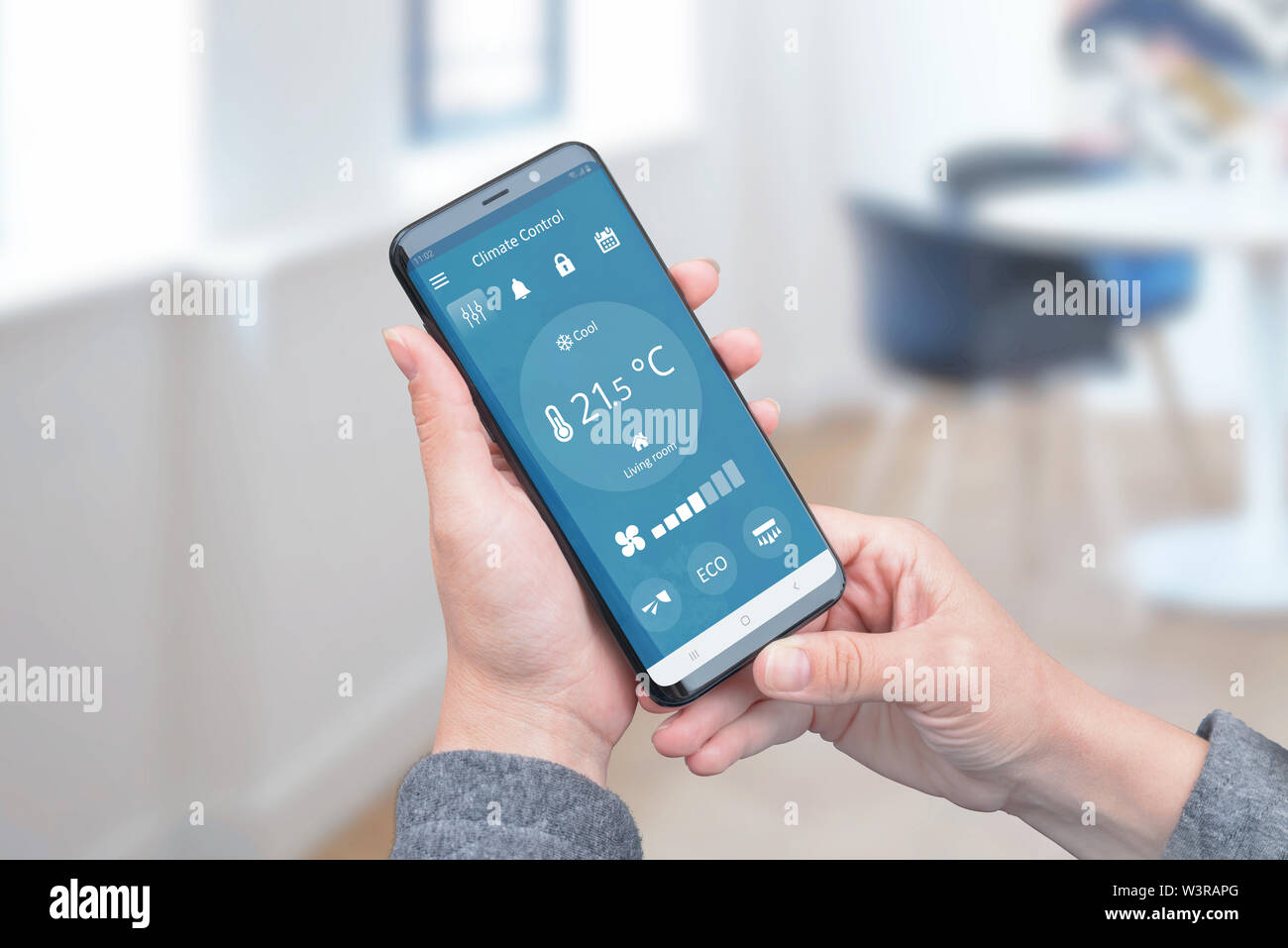 Il controllo del calore in casa con una semplice applicazione sul telefono per il controllo remoto di condizionatori d'aria. Il concetto di efficienza energetica, di risparmio e di ecologia. Foto Stock