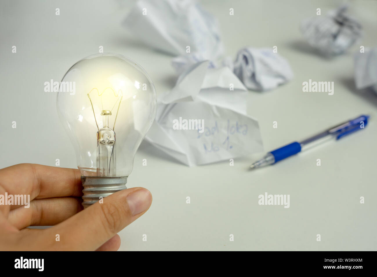 Carta increspata con un bulbo di luce e penna ha ottenuto il diritto idea concept Foto Stock