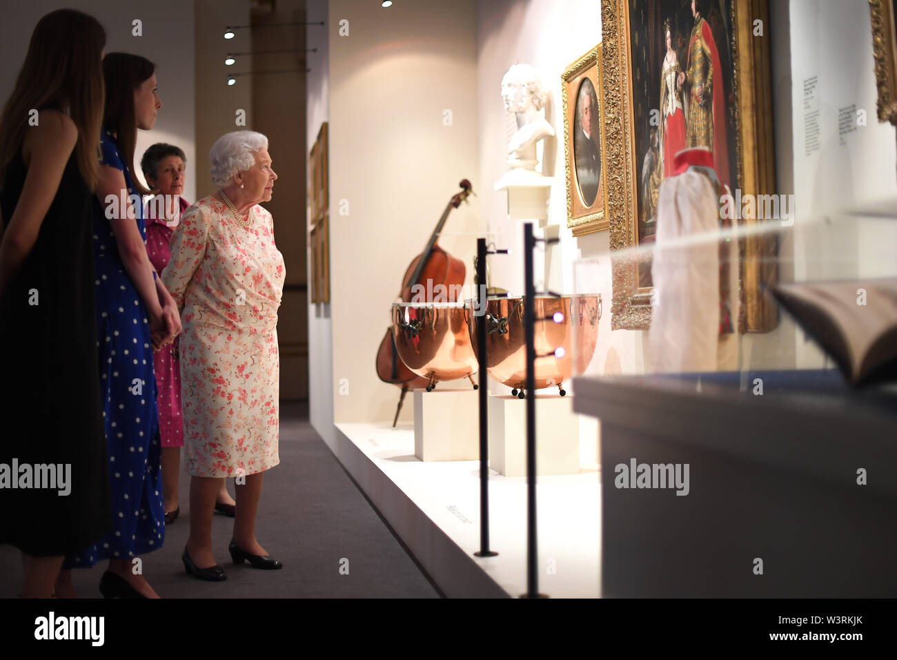 Queen Elizabeth II guarda un dipinto di Luigi Lablache, Queen Victoria's maestro di canto e Felix Mendelssohn-Bartholdy, chi ha composto la musica per la Regina e il Principe Alberto e alcuni strumenti utilizzati dalla regina Victoria's orchestra privato come parte della mostra per contrassegnare il duecentesimo anniversario della nascita della regina Victoria per l'apertura estiva di Buckingham Palace di Londra. Foto Stock