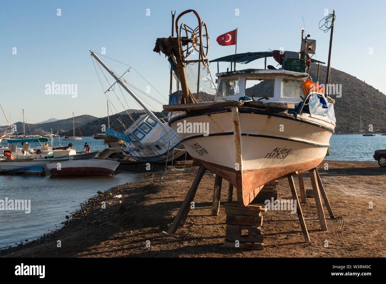 Più barche di pescatori locali, tra cui uno sui cunei sulla spiaggia per la manutenzione, Bozburun, Turchia Foto Stock