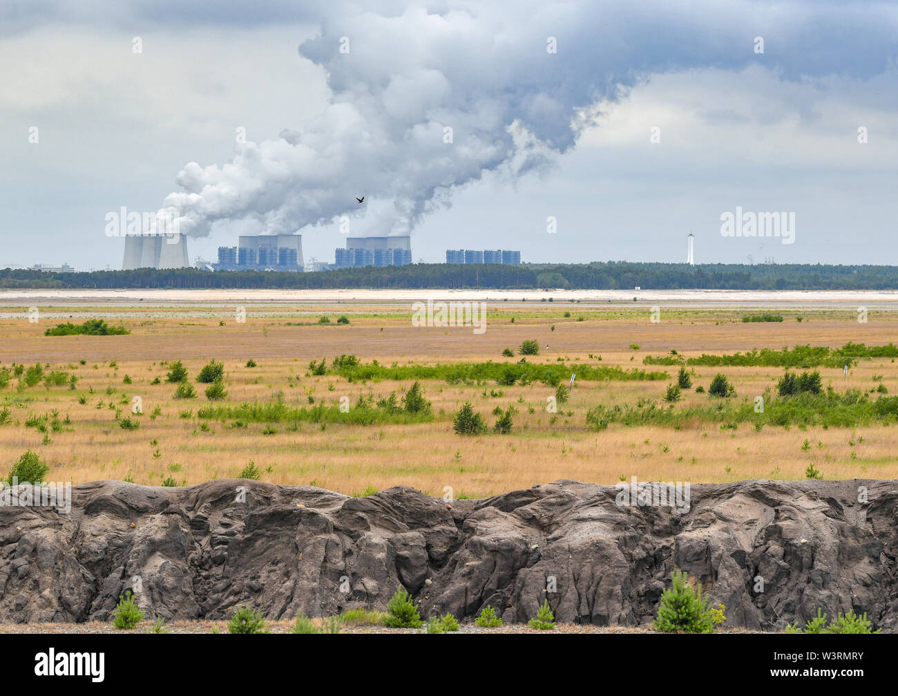 Il 15 luglio 2019, il Land Brandeburgo, Cottbus: la vaporizzazione delle torri di raffreddamento di Jänschwalde alimentato a lignite impianto di alimentazione può essere visto dietro la ex Cottbus-Nord a cielo aperto della miniera di lignite, il futuro Cottbus del Mar Baltico. Tutta la zona sabbiosa in primo piano sarà coperto con acqua una volta. Il Cottbus del Mar Baltico è stato creato. Le inondazioni dell'ex Cottbus-Nord miniera a cielo aperto ha cominciato a metà aprile 2019. A causa della siccità rinnovata quest'anno, le inondazioni del gran buca è già stata sospesa per diverse settimane. Secondo l'operatore, la società energetica Lausitz Energie Bergbau AG (LEAG), l'acqua fluirà Foto Stock