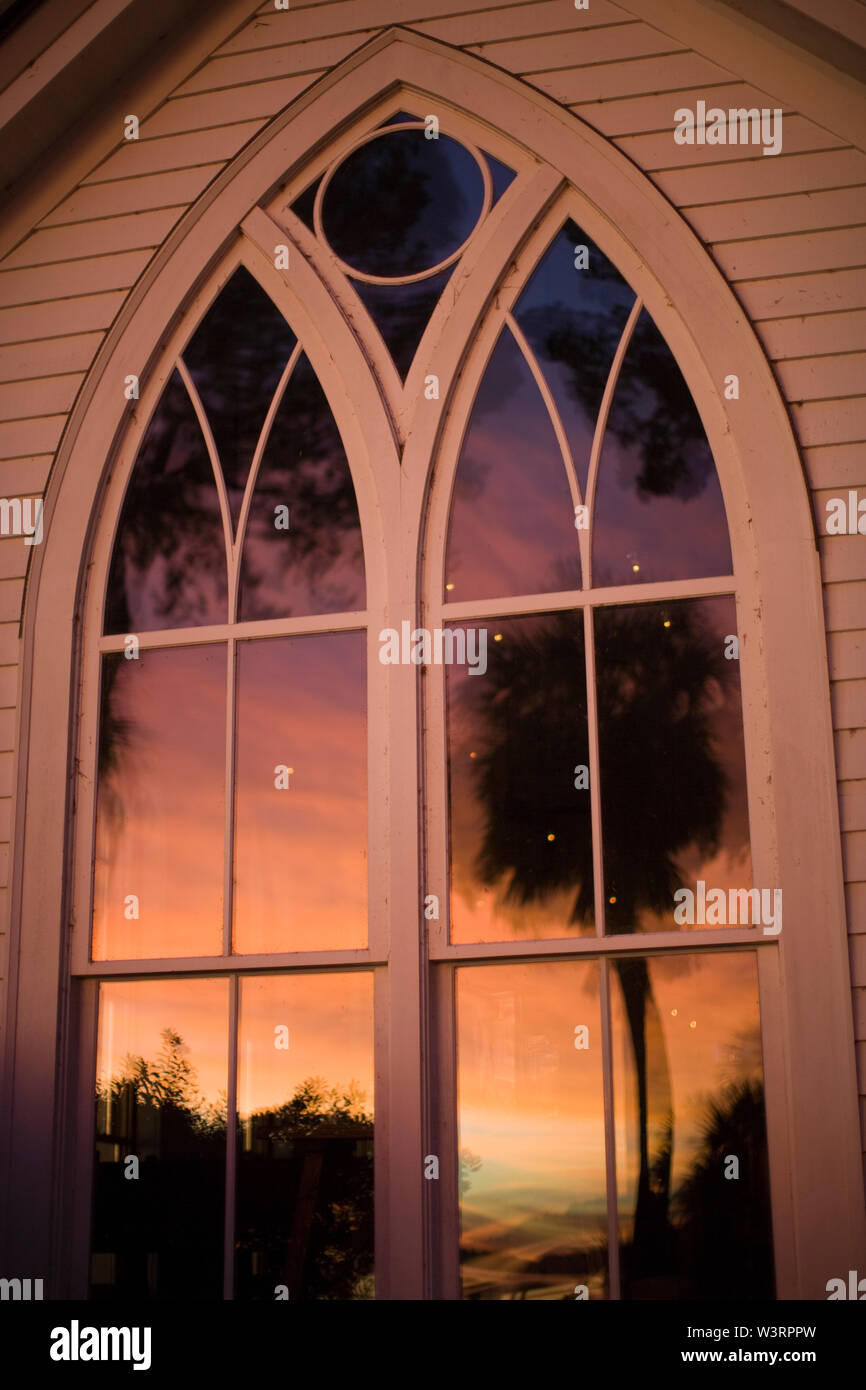 Tramonto riflesso nella chiesa windows Foto Stock