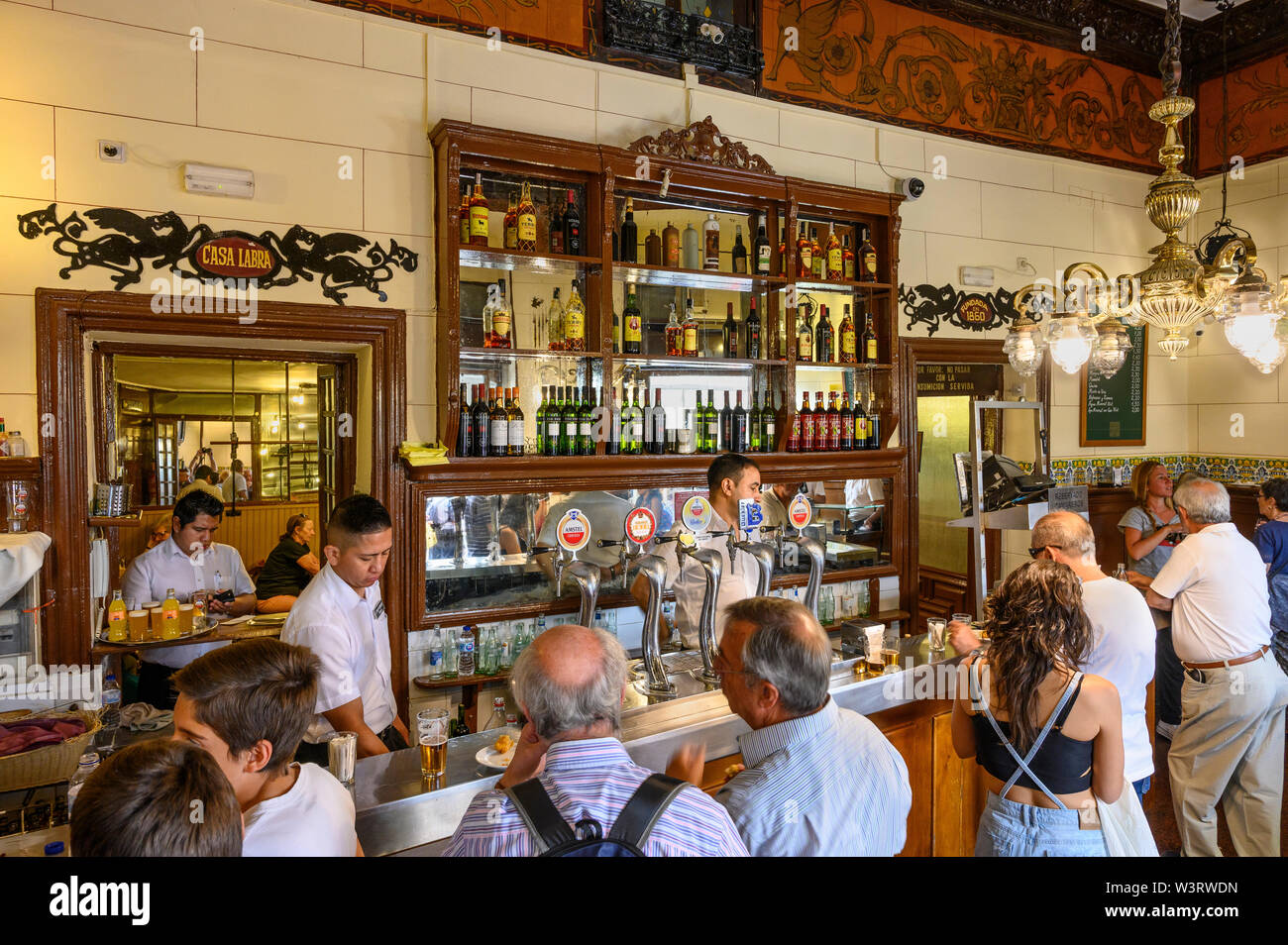 Persone bere e mangiare presso il bar in Casa Labra un vecchio famoso bar / taverna specializzata in Bacalao e altri tapas, vicino alla Puerta del Sol , in Foto Stock