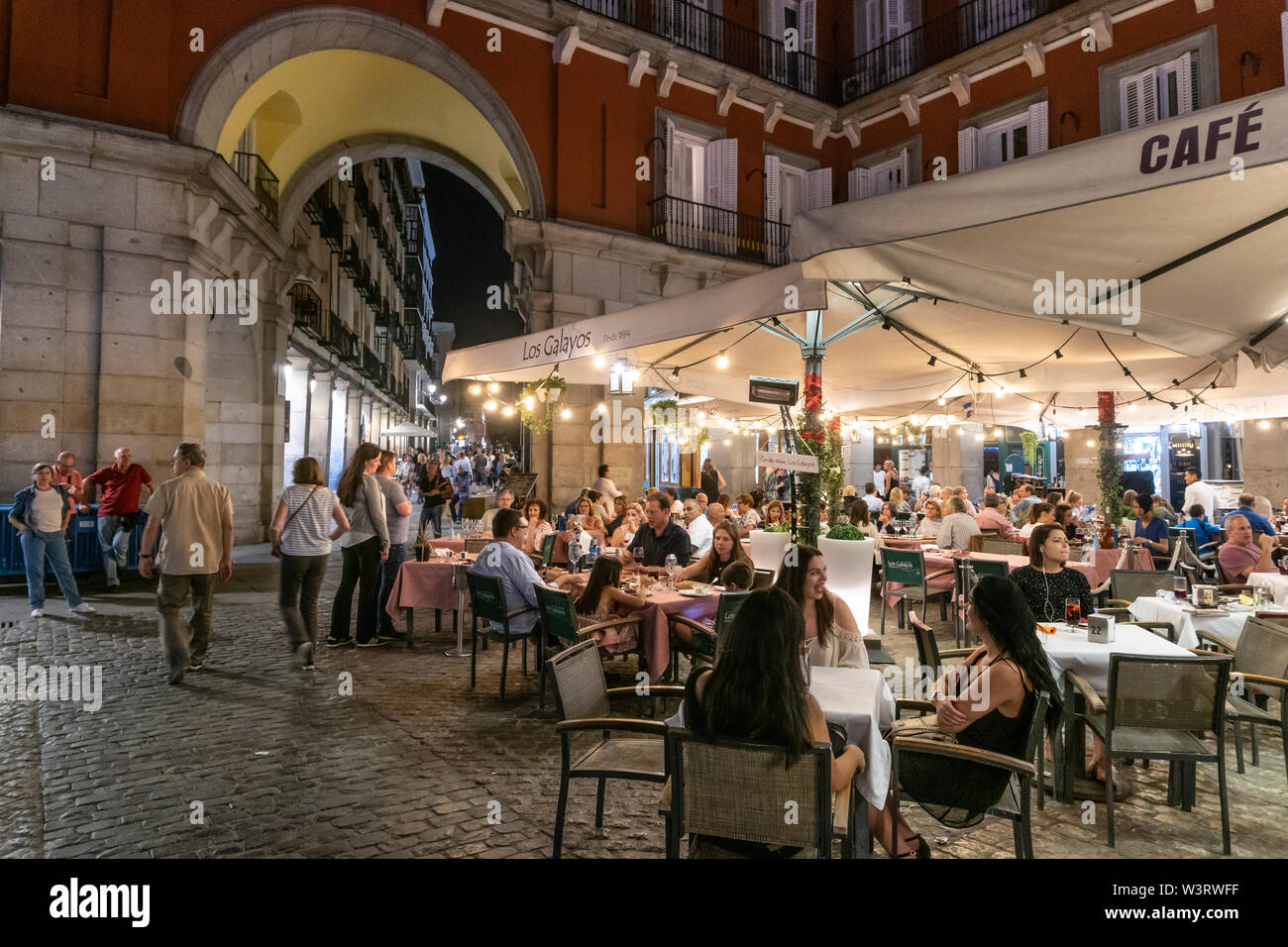 Persone mangiare fuori la sera nella Plaza Mayor, nel centro di Madrid, Spagna Foto Stock