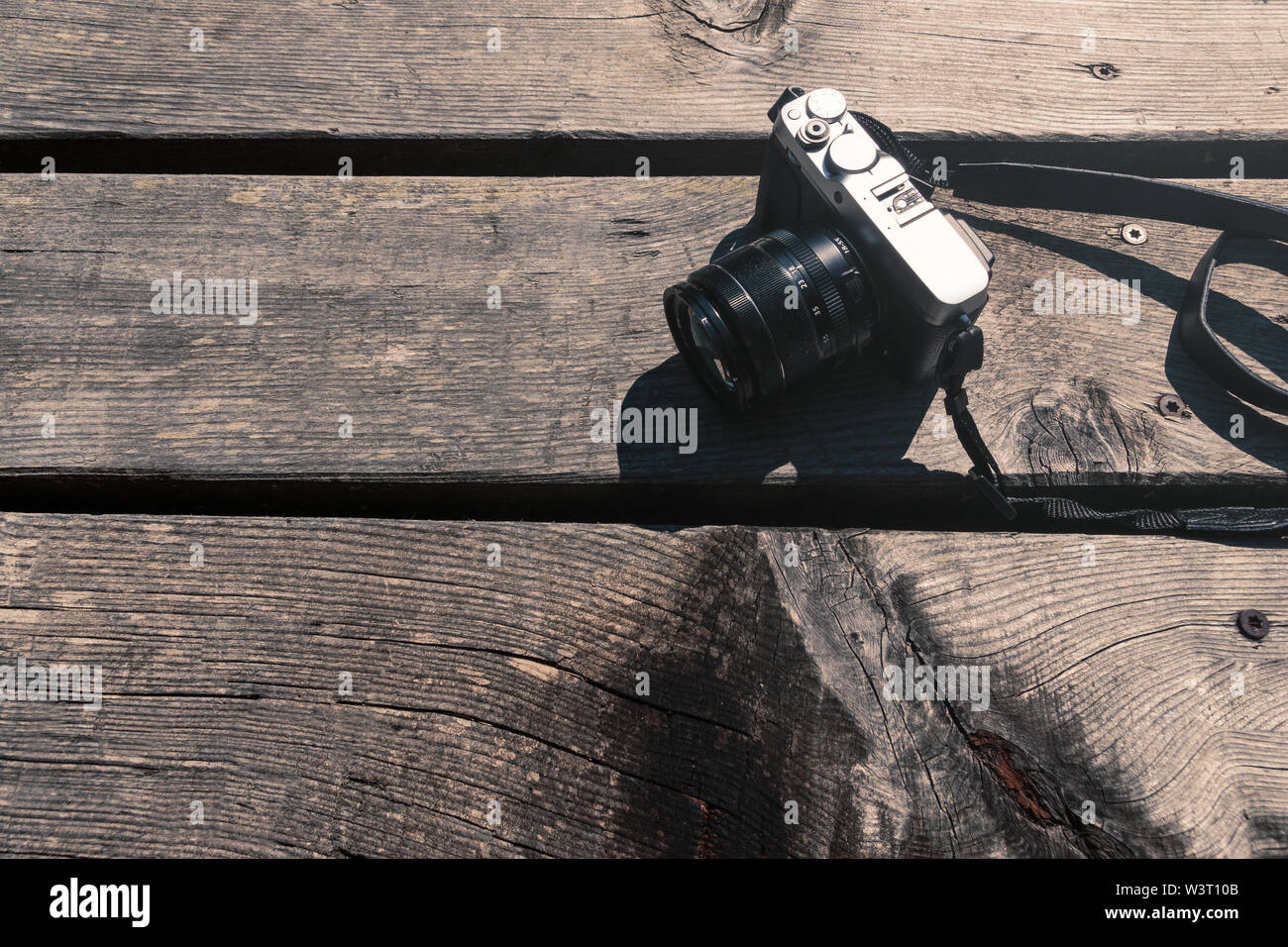 In stile vintage grigio e nero foto fotocamera su un tavolo di legno fuori nel sole vista da sopra Foto Stock