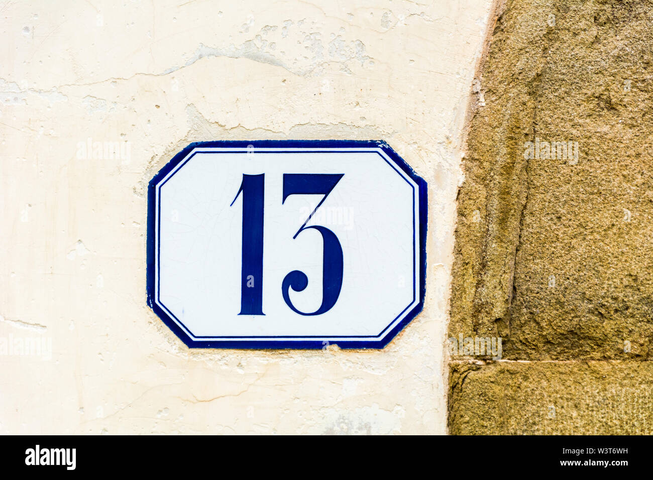 Il numero civico tredici ( 13 ) su una parete roughcast Foto Stock