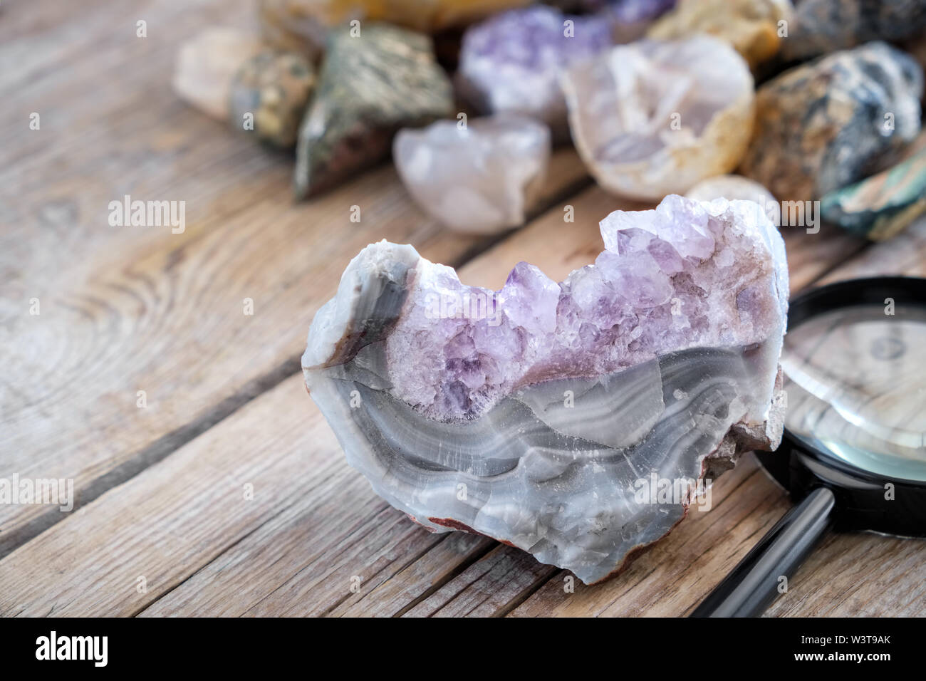 Pietre minerali collezione. Ametista con agata e lente di ingrandimento in  primo piano Foto stock - Alamy