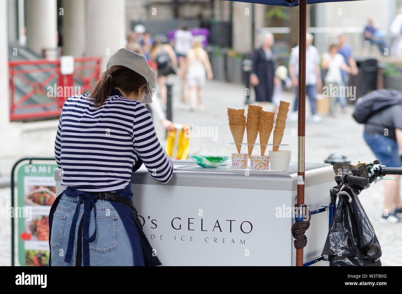 Ragazza giovane è la vendita di gelato il gelato in London street, vicino al Tower Bridge. Foto Stock