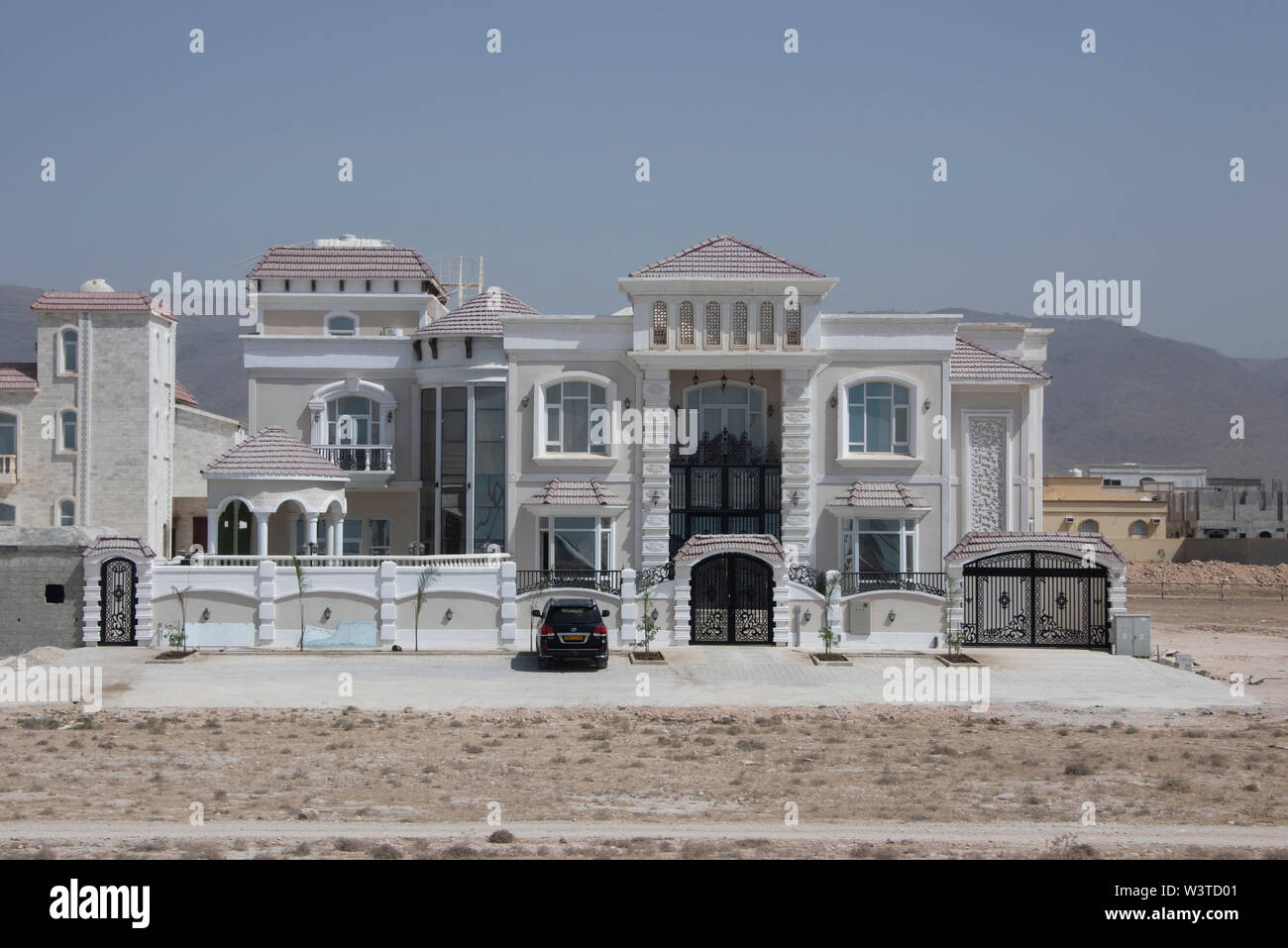Oman, regione di Dhofar, la città capitale di Salalah. Tipico quartiere nel deserto con la casa nuova costruzione. Foto Stock