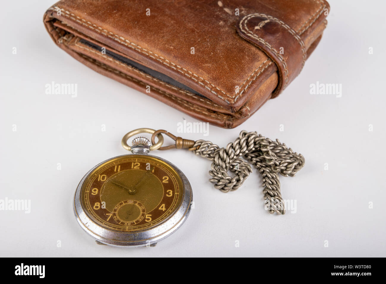 Portafoglio in pelle e un vecchio orologio su un tavolo bianco. Documenti personali in copertina in pelle. Sfondo chiaro. Foto Stock