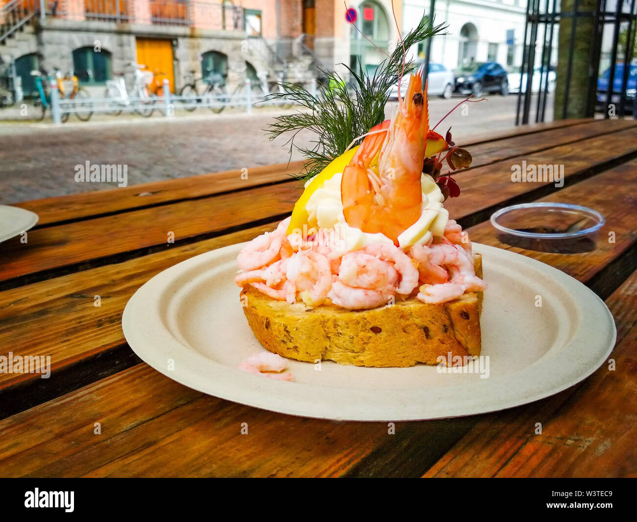 Sandwich freschi con gamberi e limone in stile danese, si tratta di un pasto delizioso. La colazione è servita su una piastra su un tavolo di legno a Copenaghen. Foto Stock
