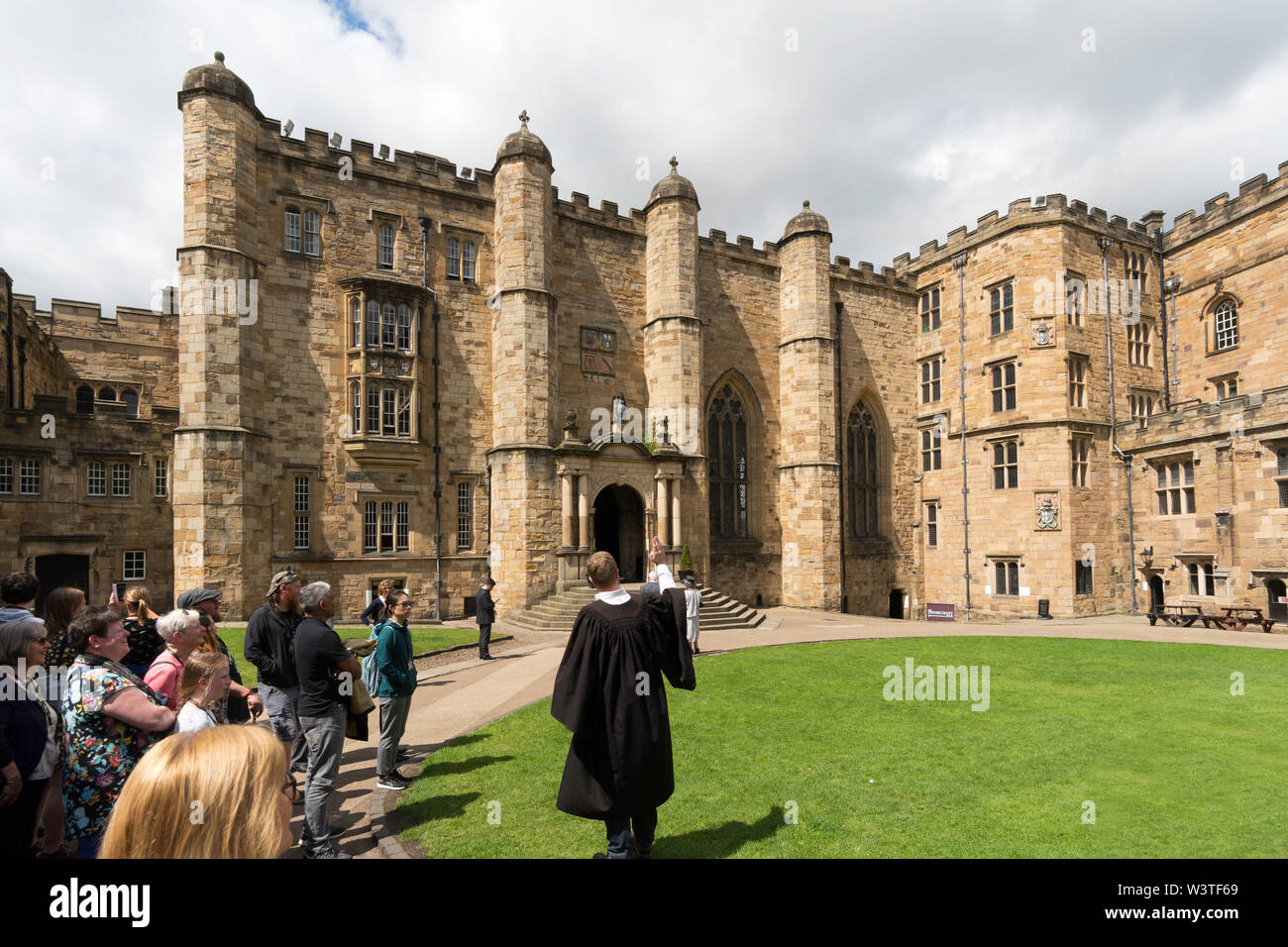 Un gruppo di visitatori con un diploma post-tour guida nel cortile del castello di Durham, parte dell'Università di Durham, England, Regno Unito Foto Stock