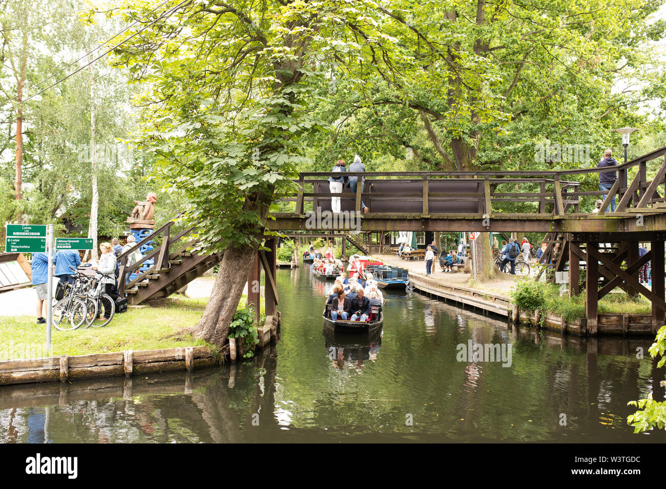 Un tour in barca passa sotto un ponte pedonale a Lehde, un villaggio nello Spreewald a Lübbenau, in Germania. Foto Stock
