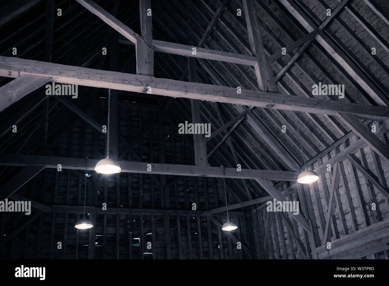 Vista interna del vecchio tetto in legno struttura in legno con travi a vista in legno nel vecchio fienile. Dark foto effetto. Foto Stock