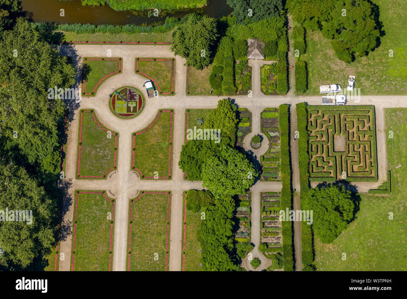 Veduta aerea del castello Bergère con giardino barocco e il letto con il simbolo della città di Gelsenkirchen con il giardiniere, che lavora nel letto di fiori con la guida Foto Stock