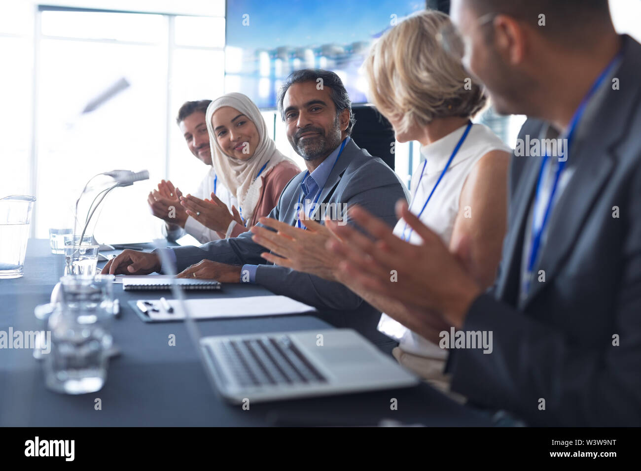 La gente di affari ad applaudire al tavolo della sala conferenze Foto Stock