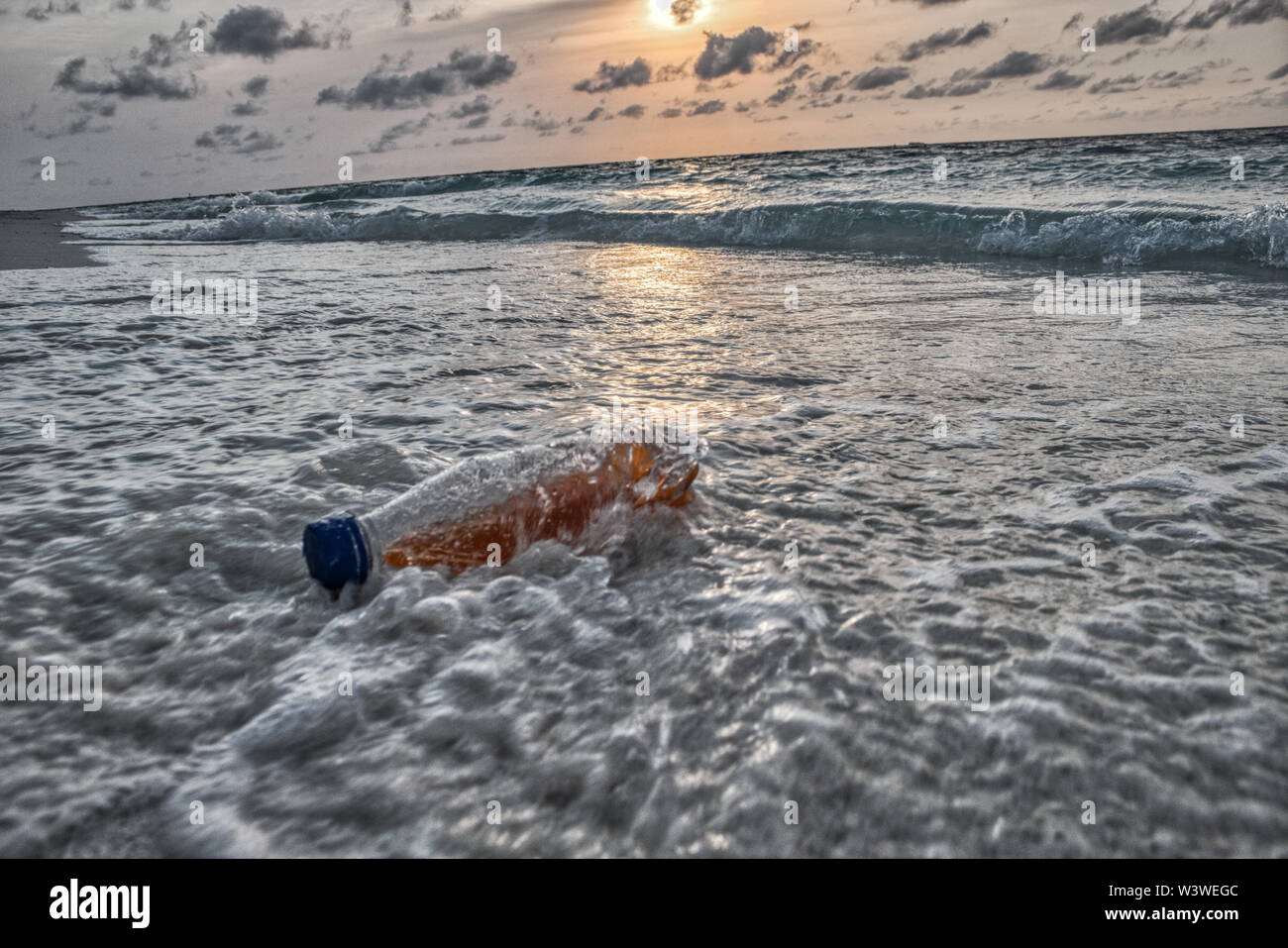 Questa singolare mostra fotografica di una bottiglia di plastica dal mare della spiaggia di Maldive Foto Stock