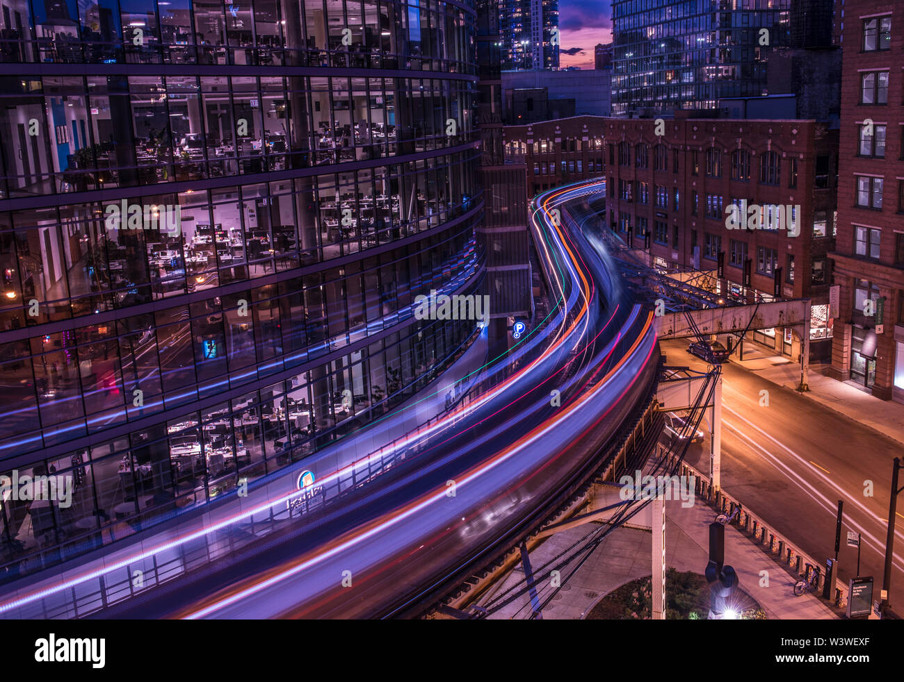 Sentieri di luce, da due Chicago EL treni, da pozzi Kinzie Garage nei pressi di Merchandise mart stazione, al crepuscolo Foto Stock