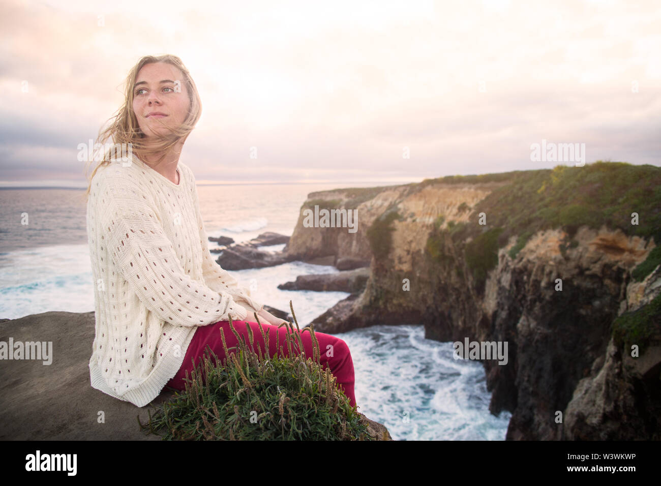 La donna si guarda indietro oltre l'Oceano Pacifico Foto Stock
