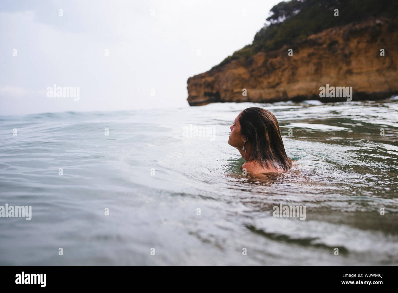 Donna swiming in spiaggia selvaggia in Tarragona, Spagna. Foto Stock