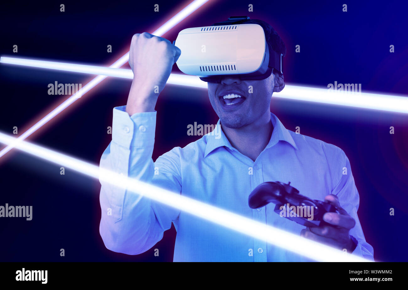 Immagine composita di happy businessman con occhiali vr clenching pugno durante la riproduzione del video gioco Foto Stock