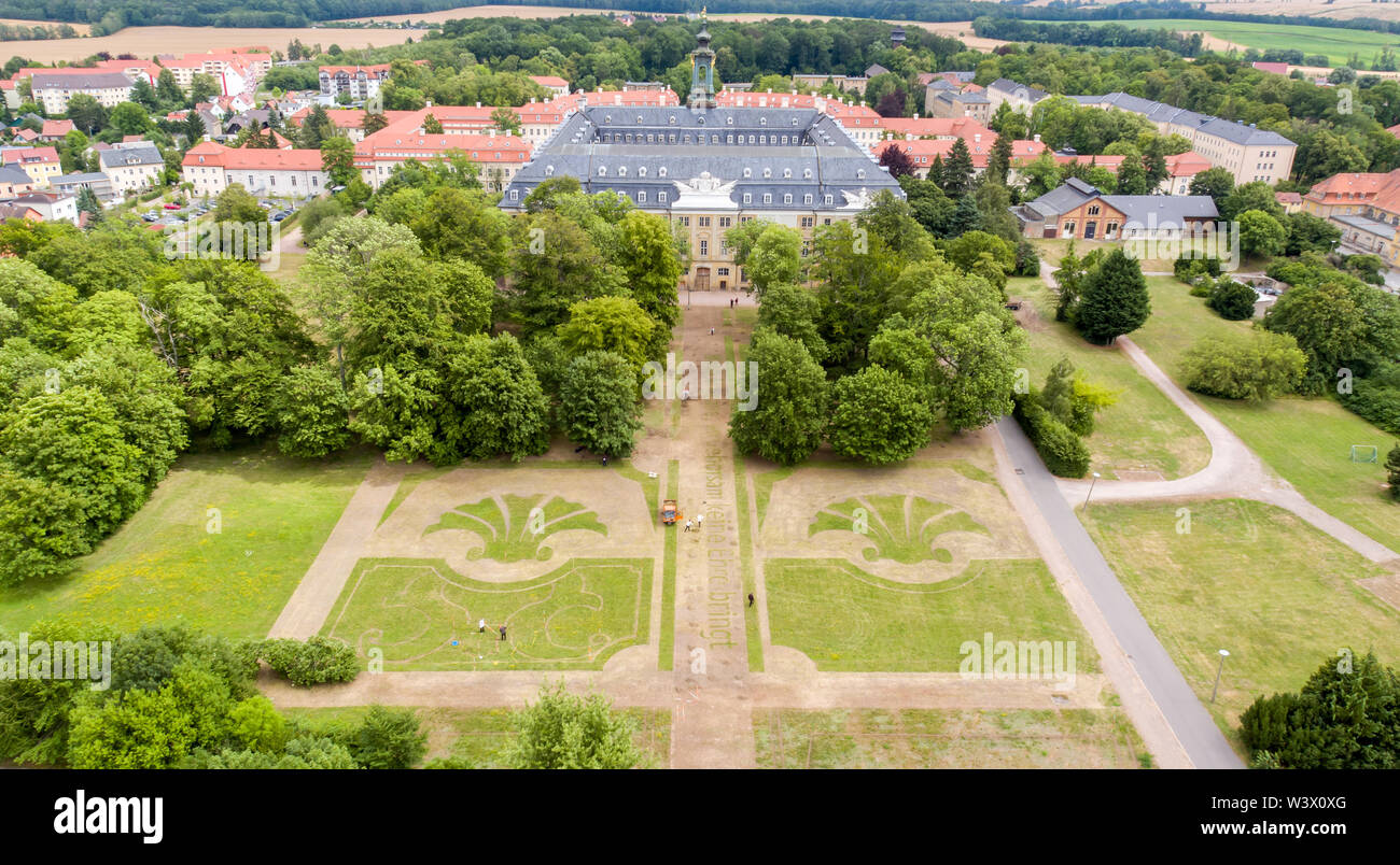 16 luglio 2019, in Sassonia, Wermsdorf: aiutanti dell'azione artista Witthaus mow le linee dell'ex giardino barocco in prati nel parco di Schloss Hubertusburg (shot con un drone). In Europa la più grande riserva di caccia ha restituito una frazione del suo giardino perduto. Con circa 40 volontari, la Colonia azione artista ha tagliato alcune delle forme centrale di gioielleria in ex park dal 1 luglio. Su 10.000 metri quadrati, l'asse centrale e la parte centrale del giardino barocco composizione sono stati resuscitati - un decimo dell'ex complesso. Ma i visitatori del 'sassone Versailles' hanno per cur Foto Stock