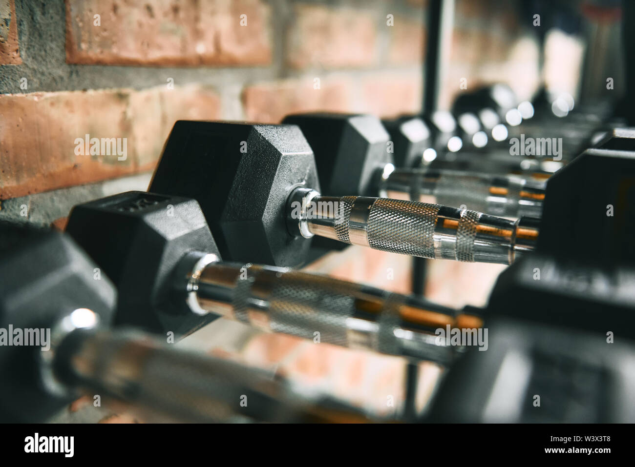 Righe di manubri. In prossimità di molte black metal manubri su rack in palestra. Esercizi di peso. Peso attrezzatura di formazione Foto Stock