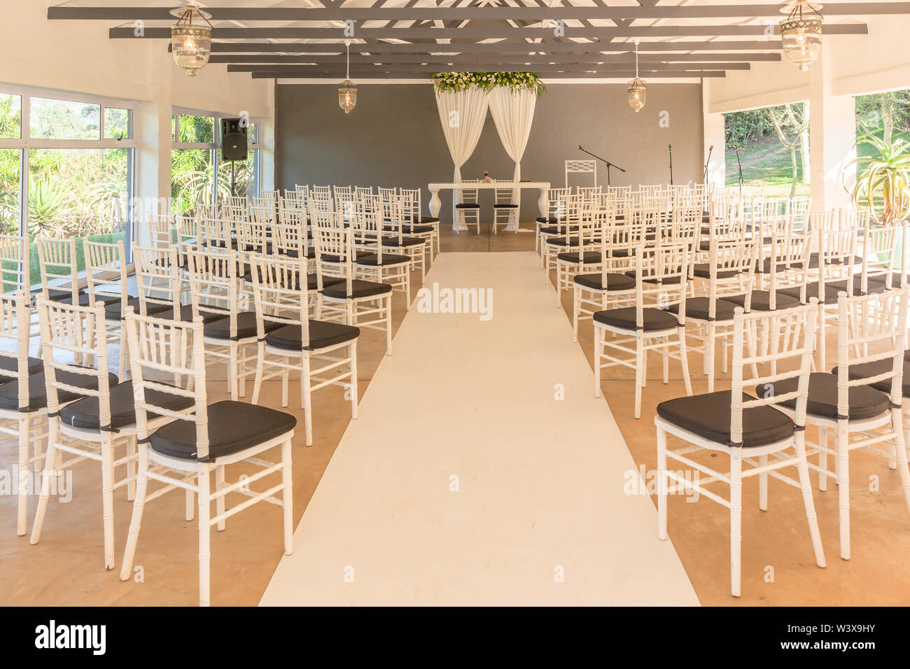 Decor Wdding impostazione sedie tavolo fiori a pianta aperta struttura hall con bianco grigio colore del tema in sede Foto Stock