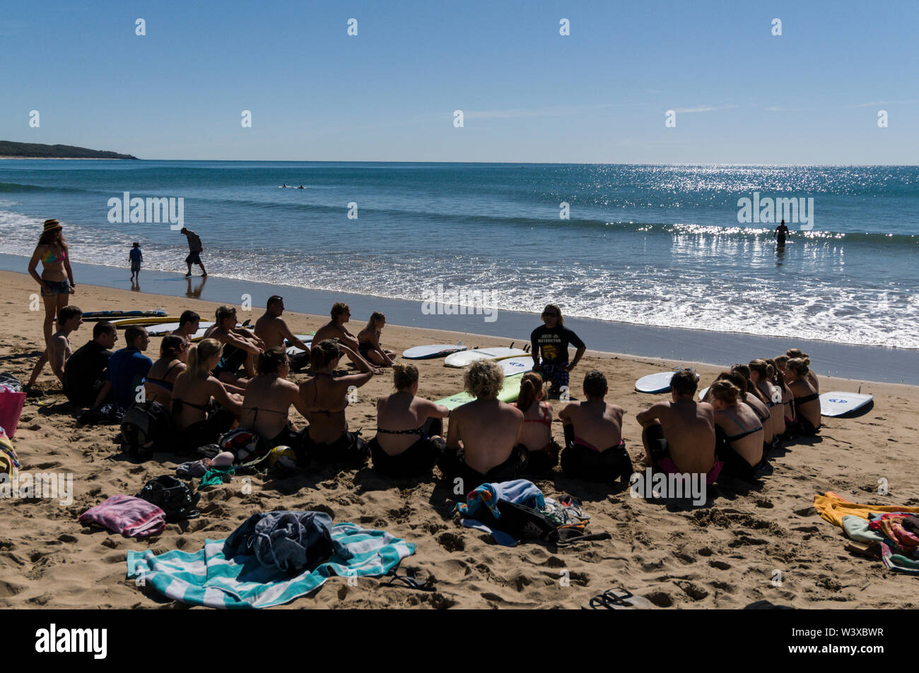 Un gruppo di giovani backpackers la loro prima lezione di surf con un istruttore presso Agnes Water Beach caravan e campeggio nel Queensland, in Australia. Foto Stock